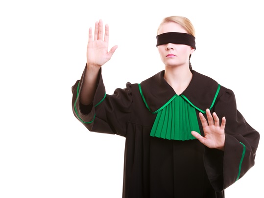 Lawyer attorney in classic polish gown covering eyes with blindfold
